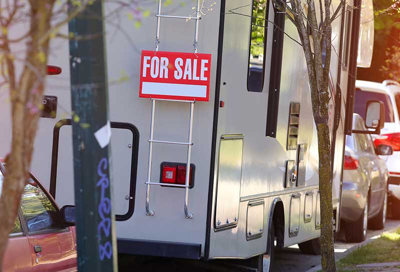 For sale sign on a parked motorhome before rv inspection services are scheduled 