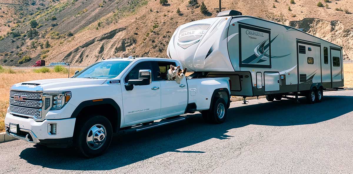 Towable motorhome camper being pulled by a truck with two dogs after an RV inspection